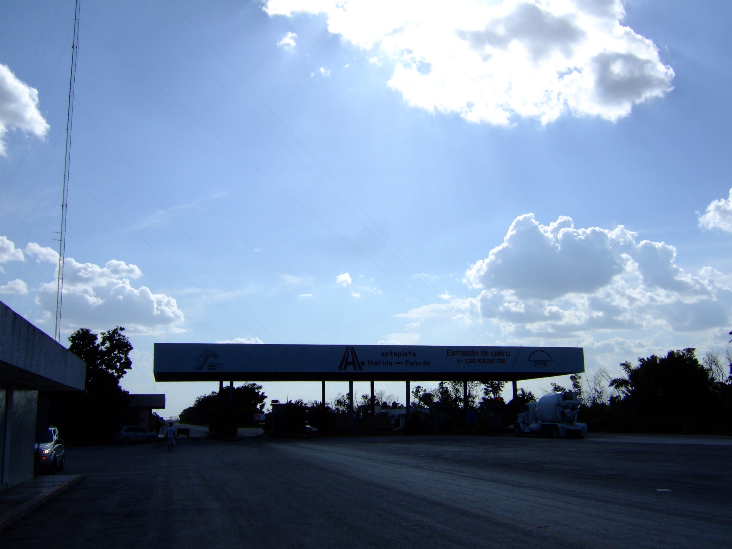 Empty toll plaza canopy on the Merida to Cancun autopista, silhouetted against a late-afternoon sky