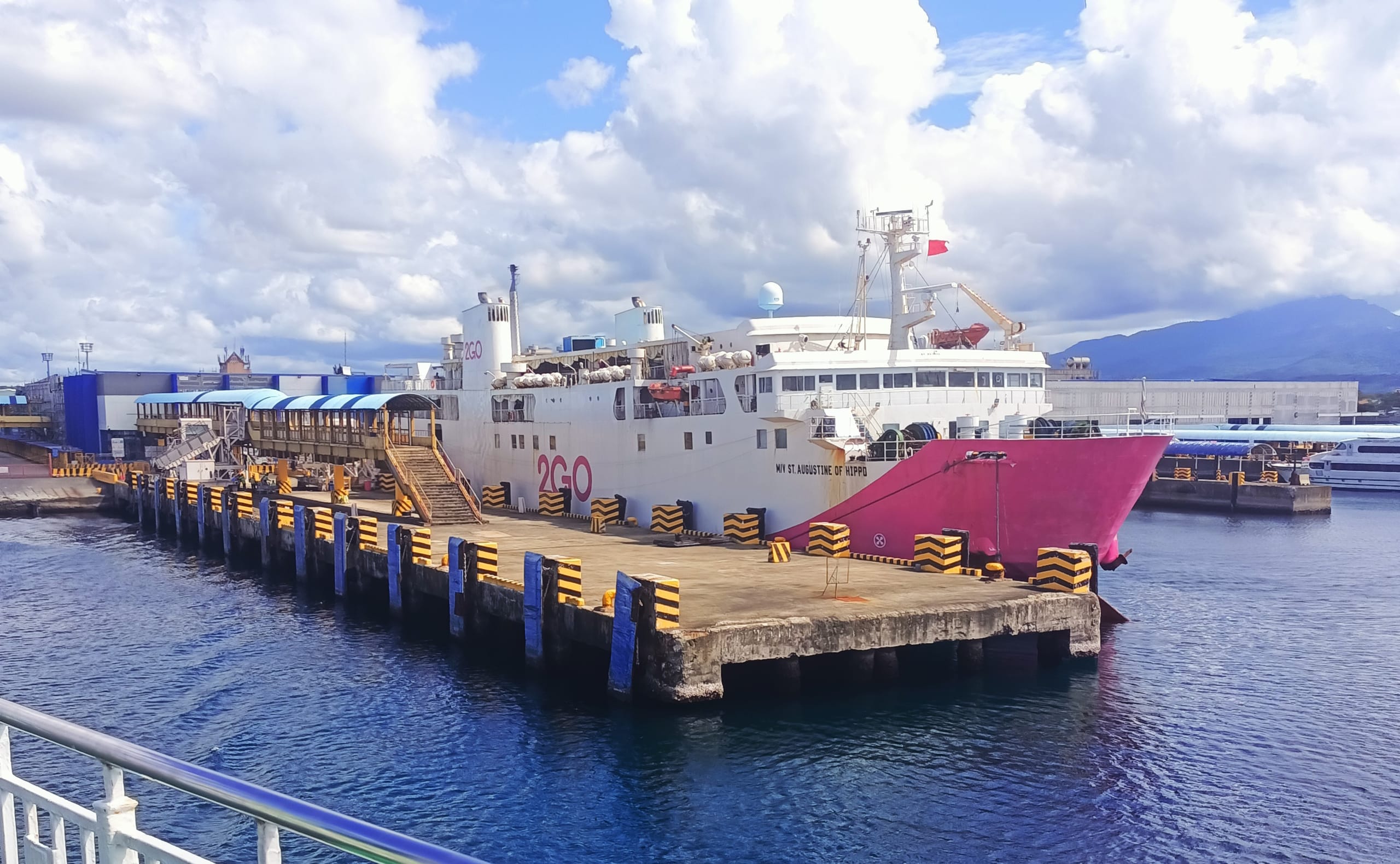 The 2GO ferry St. Augustine of Hippo docked at a pier in Batangas City with a covered boarding walkway