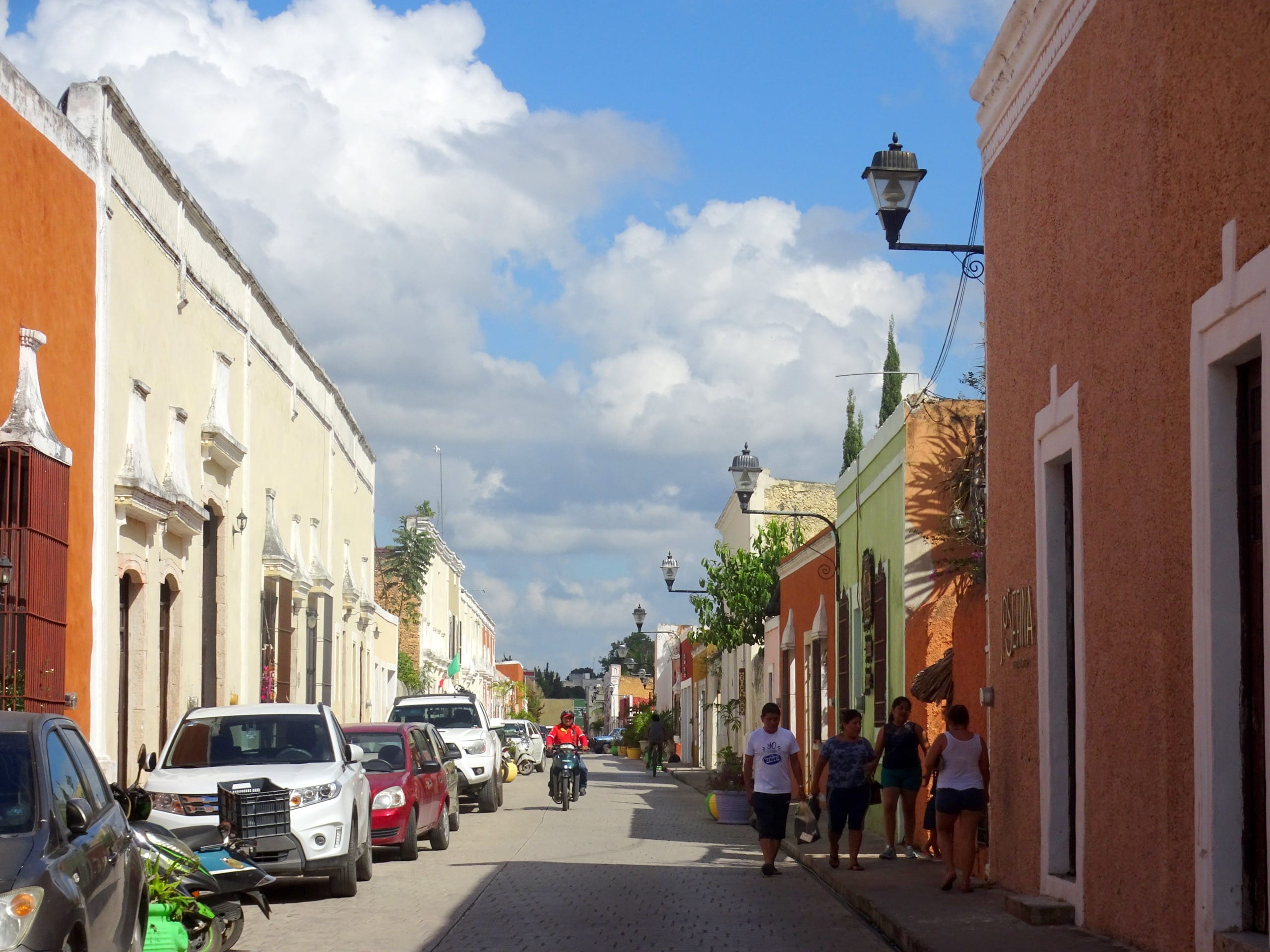 Colorful colonial facades and parked cars along the Calzada de los Frailes in Valladolid