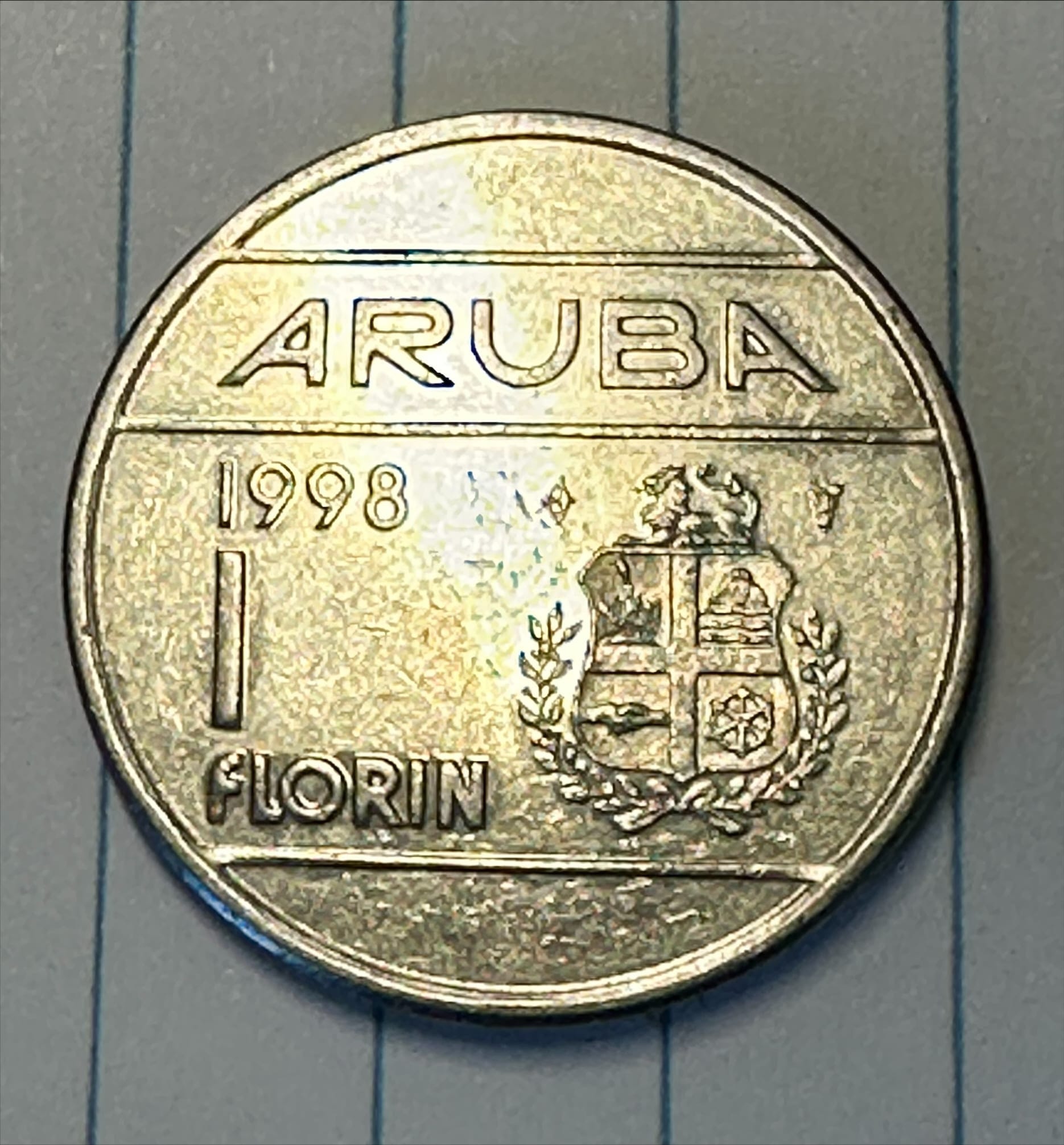 A 1 florin coin dated 1998, the Aruban coat of arms stamped on its face